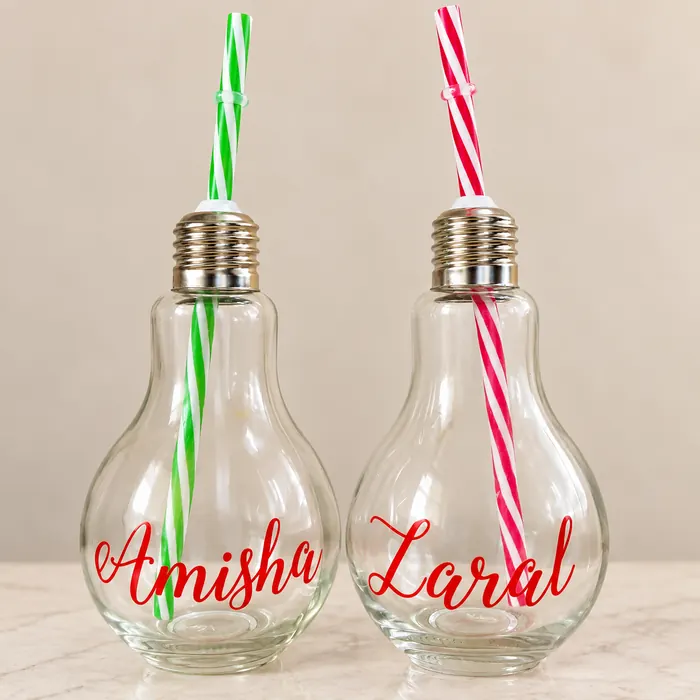 Two bulb-shaped glass bottles printed with the names Amisha and Zaral in red