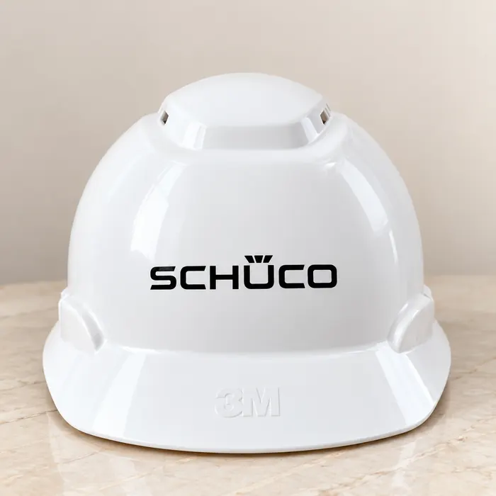 White safety helmet screen printed with the Schüco logo